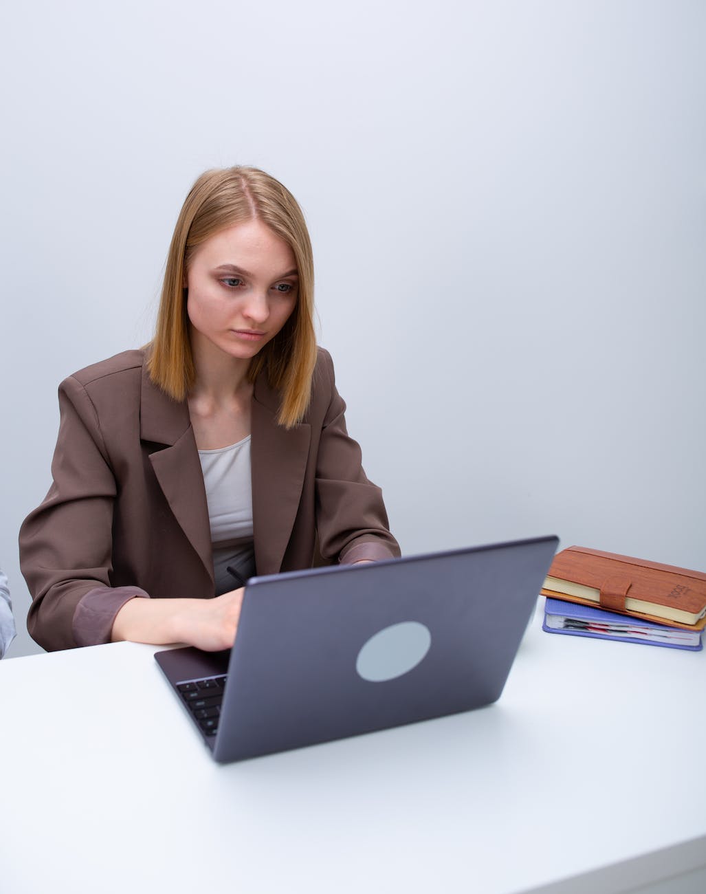 a woman in a blazer using her laptop